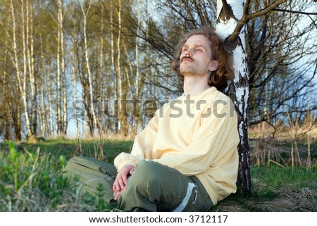Young man dream of something near birch at nature