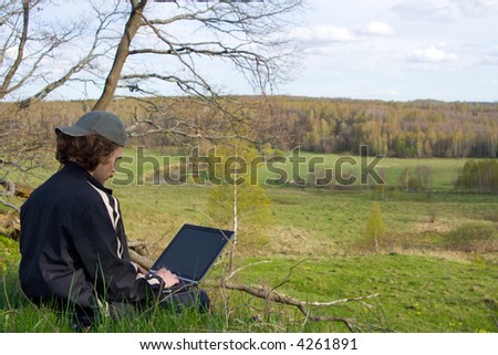 Man with portable computer near small river at nature.