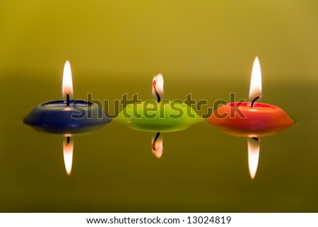 Three candles in water - red, green and blue.