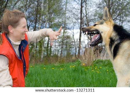 Woman and alsatian dog making faces to each other