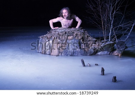 Water sprite at snag stump at the middle of frozen pond in winter night