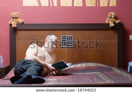 Man read some book at his modern bedroom in red tones