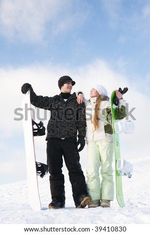 Couple having fun on snowboards at winter day