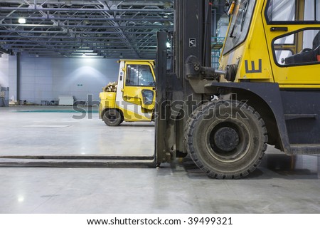 Two loaders in modern storehouse