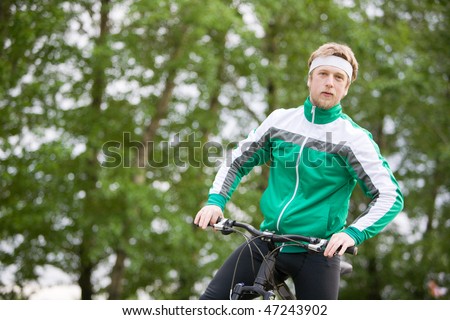Portrait of man in track-suit with his bicycle