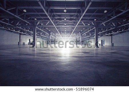 Modern empty dark storehouse with light at the end