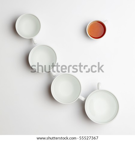 Several different cups with water and smallest with tea standing out of the crowd
