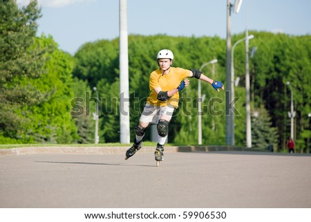 Young man on rollerblades skating at park