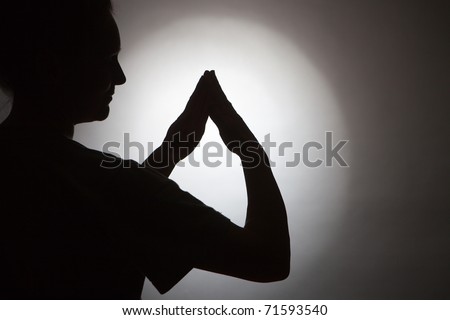 Silhouette of woman and her hands in form of a house