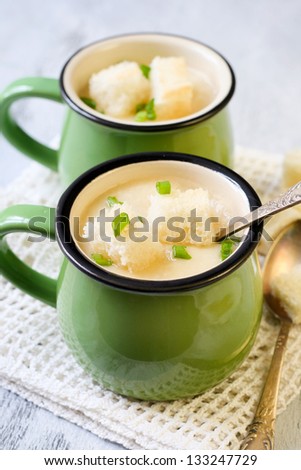 Cauliflower soup with croutons and spring onion in served in cups