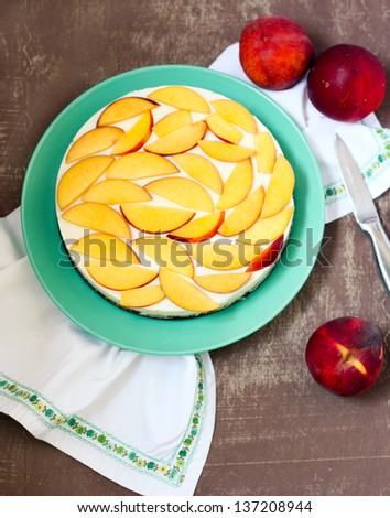 Yogurt mousse peach cake decorated with slices of peaches