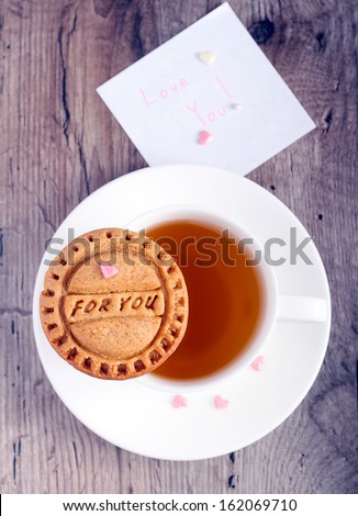 Homemade ginger cookies with stamp: for you and cup of tea and note with words Love you