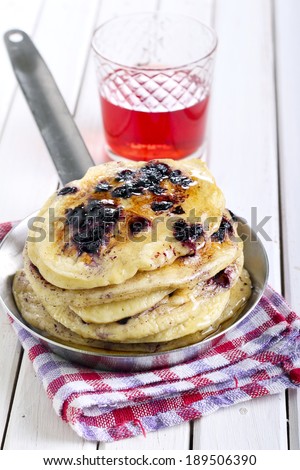 Blueberry pancakes in a pan with honey
