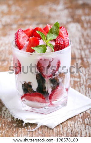 Chocolate cookies, cream and strawberry dessert in glass