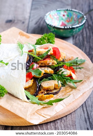 Tortilla filled with grilled chicken, aubergine, tomato and rocket