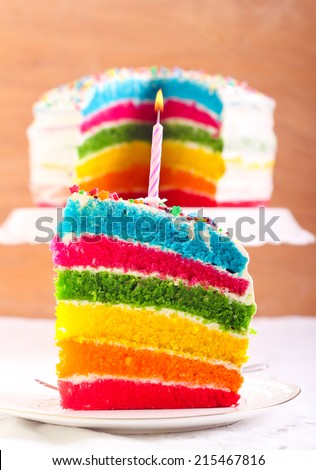 Rainbow cake slice with candle on top
