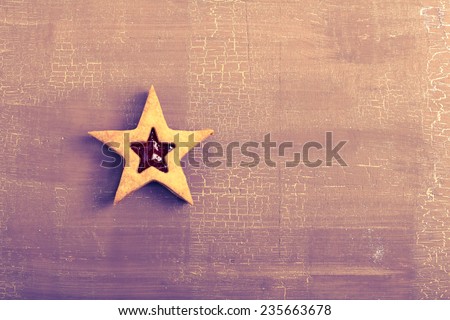 Star biscuit with jam filling over painted background, tanned retro