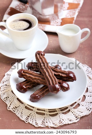 Chocolate Viennese fingers biscuits with chocolate glaze on tops and coffee