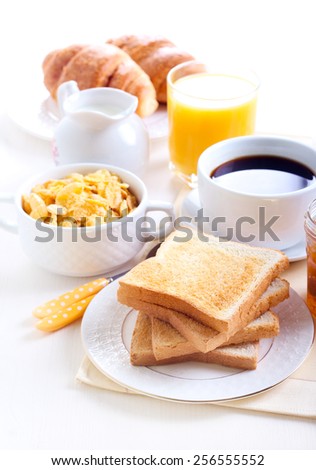 Breakfast: toasts, marmalade, cup of coffee, orange juice, cornflakes