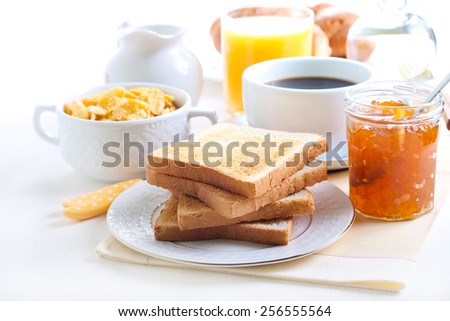 Breakfast: toasts, marmalade, cup of coffee, orange juice, cornflakes