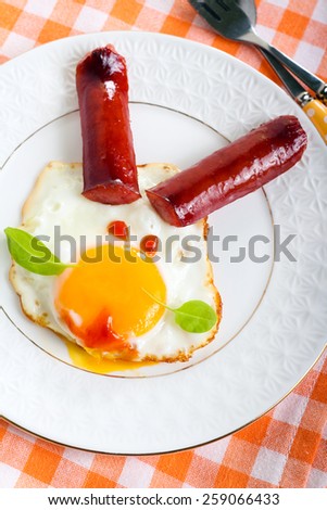 Fried egg and sausage decorated as a bunny face