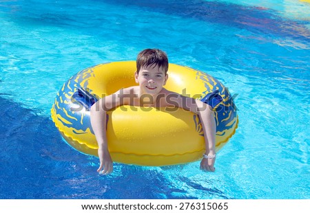 Boy in the swimming pool on inner tube