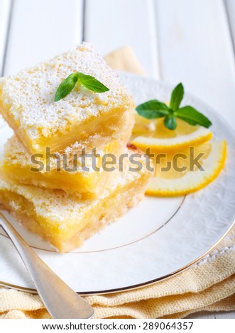 Tangy lemon squares with icing sugar on rack