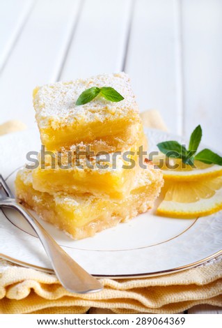 Tangy lemon squares with icing sugar on plate