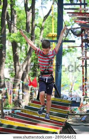 Boy is climbing in rope attraction park