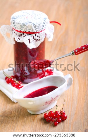 Red currant jelly sauce in a jar and spoon