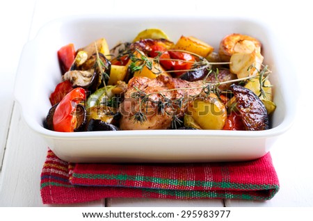 Baked vegetables and chicken drumstick in baking tin