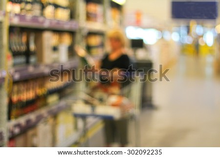 Blurred background of Supermarket and a person choosing what to take