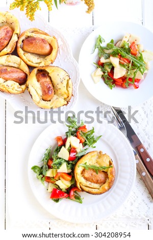 Sausage and apple Toad  in  the hole and salad on plate