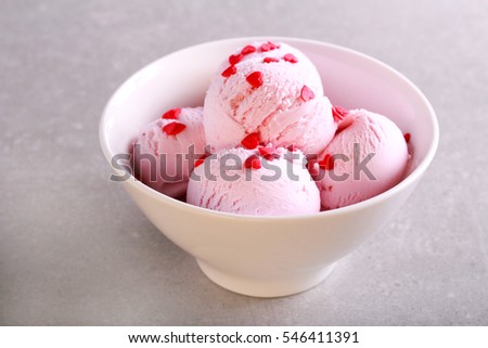 Ice cream scoops with heart shaped sprinkles in a bowl, top view