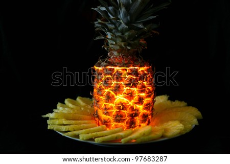 Pineapple with candle inside shining in the dark
