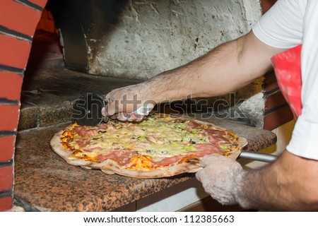 Pizza chef cutting pizza