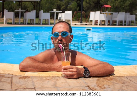 Man drinking juice in the swimming pool