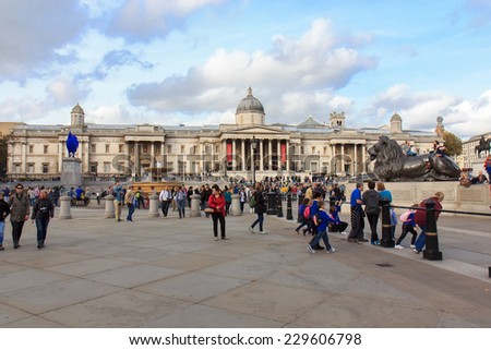 LONDON, UK - OCTOBER 17, 2014: Tourists visit Trafalgar Square October 17, 2014 in London. One of the most popular tourist attraction on Earth it has more than fifteen million visitors a year.
