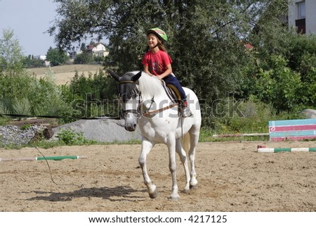 Young girl training on white horse