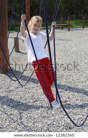 young girl playing on rope swing