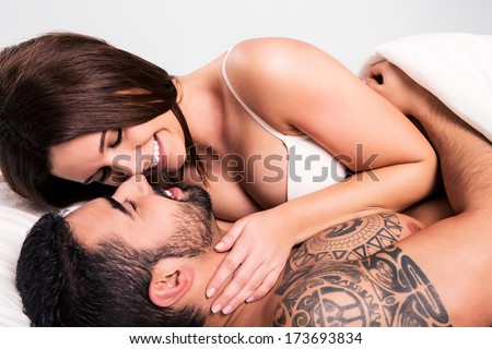 Love couple flirting and hugging in bed