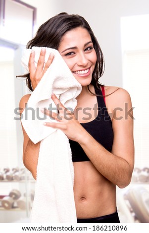 Fitness woman wiping sweat with a towel