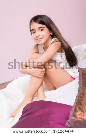 Cute smiling little girl woke up in bed