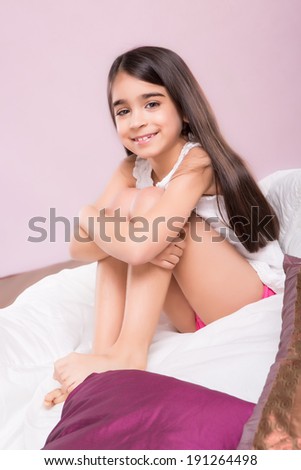 Cute smiling little girl woke up in bed