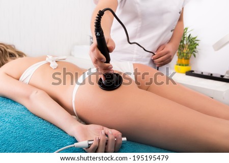 Woman getting anti cellulite and anti fat therapy in beauty salon Woman getting anti cellulite and anti fat therapy in beauty salon