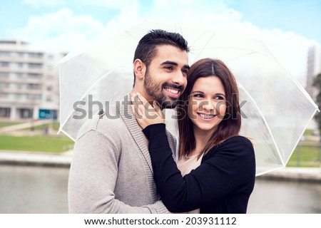 Happy couple under a white umbrella in the city