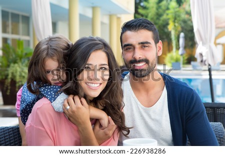 Beautiful latin family relaxing close to the pool