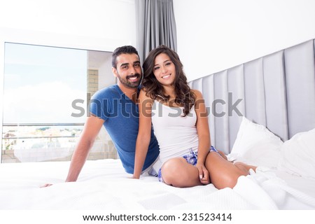 Young couple lying in bed wearing pajamas