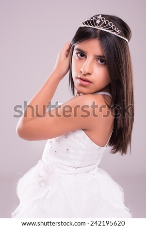 Little girl wearing princess fantasy over soft pink background