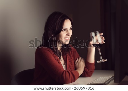 Woman in video call with a glass of wine on hand